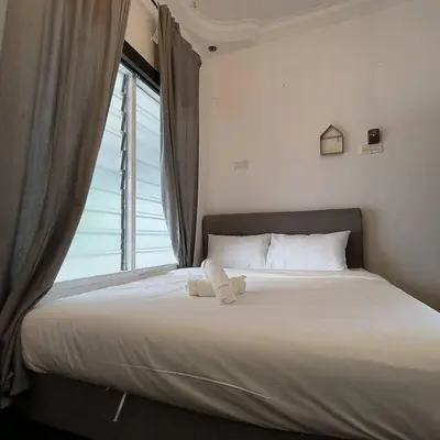 a bed in a bedroom with a large window at Getaway Hometsay Neaby Beach batu Ferringghi 4BR for 15px in Tanjung Bungah