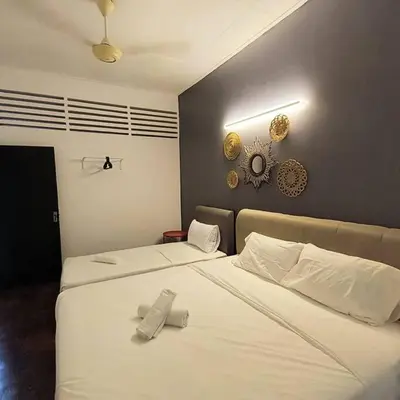 a bedroom with two beds with white sheets at Getaway Hometsay Neaby Beach batu Ferringghi 4BR for 15px in Tanjung Bungah
