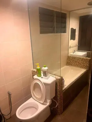 a bathroom with a toilet and a shower and a tub at A sweet home for your trip in Lumut