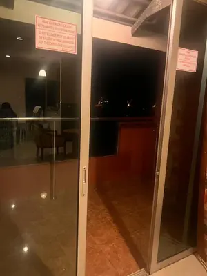 a sliding glass door in a room with a table at A sweet home for your trip in Lumut
