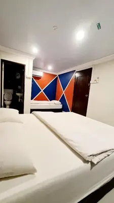 a bedroom with two beds and a colorful wall at Pine Lodge BY EVR Previously YSS indrawasih in Perai