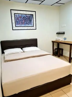 two beds in a room with a table at Pine Lodge BY EVR Previously YSS indrawasih in Perai