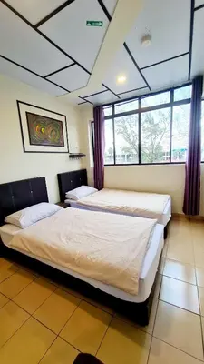 two beds in a room with windows at Pine Lodge BY EVR Previously YSS indrawasih in Perai