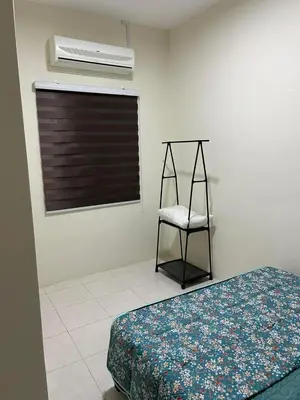 a bedroom with a bed and a chair and a window at SKV Homestay in Teluk Intan