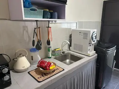 a kitchen counter with a sink and a microwave at SKV Homestay in Teluk Intan