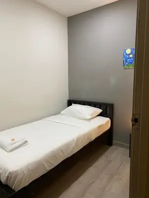a small bedroom with a bed with white sheets at Aayu Muntri - 4 mins to Chulia St George Town in George Town