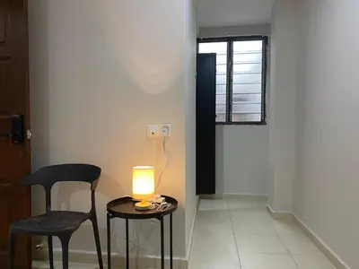 a room with a table and a chair and a lamp at Aayu Muntri - 4 mins to Chulia St George Town in George Town