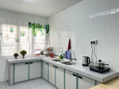 a kitchen with white tiled walls and a counter top at Ipoh Comfortable Family Homestay 4R3B 12pax SY25 in Ipoh