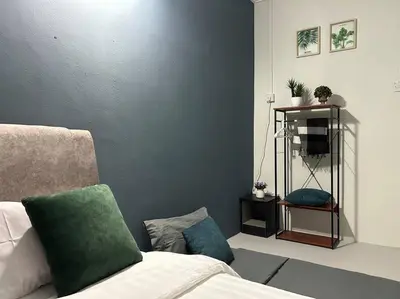 a living room with a couch and a green pillow at Ipoh Comfortable Family Homestay 4R3B 12pax SY25 in Ipoh