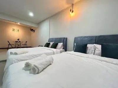 three beds in a room with white sheets at Ipoh Comfortable Family Homestay 4R3B 12pax SY25 in Ipoh