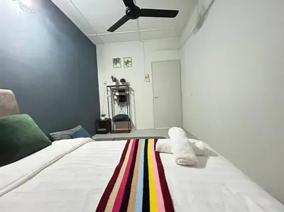 a bedroom with a white bed with a colorful rug at Ipoh Comfortable Family Homestay 4R3B 12pax SY25 in Ipoh