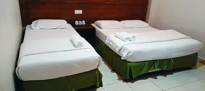 two beds sitting next to each other in a room at Kampar Times Inn Hotel in Kampar