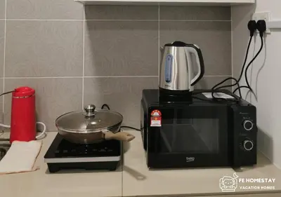 a microwave sitting on a counter with a pot on top at FE Cozy Ipoh Homestay Manhattan Condominium Ipoh Waterpark 3BR 8 pax by FE Homestay \u6021\u4fdd\u6c11\u5bbf \u6c34\u4e0a\u4e50\u56ed in Ipoh