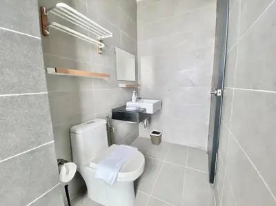 a bathroom with a white toilet and a sink at Urban Suites #Soft creamy #Infinity Pool #local neighbourhood #4pax #2BR 2bath #2Queen #Quality well maintained #Private host in Jelutong