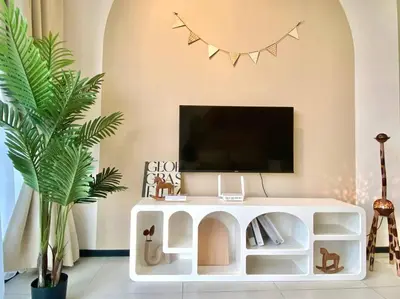 a living room with a tv and a white entertainment center at Urban Suites #Soft creamy #Infinity Pool #local neighbourhood #4pax #2BR 2bath #2Queen #Quality well maintained #Private host in Jelutong