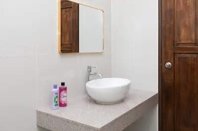 a bathroom with a white sink and a mirror at Tanjung Bungah 5BR Villa w pool 20pax in Tanjung Bungah