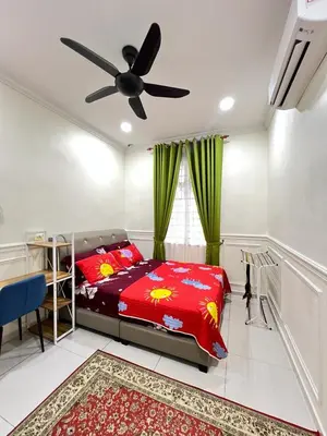 a bedroom with a bed and a ceiling fan at De Raisha Homestay in Butterworth
