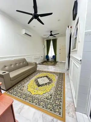 a living room with a couch and a rug at De Raisha Homestay in Butterworth