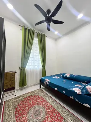a bedroom with a bed and a ceiling fan at De Raisha Homestay in Butterworth