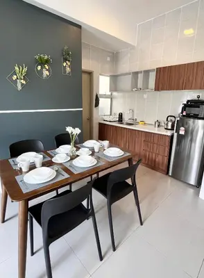 a kitchen with a wooden table and black chairs at Aloft Cameron Highlands C in Brinchang