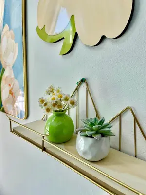 a shelf with a green vase and flowers on it at Aloft Cameron Highlands C in Brinchang