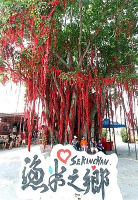 a tree with red streamers hanging from it at Sekinchan Fragrance \u82ac\u82b3\u6c11\u5bbf in Sekincan