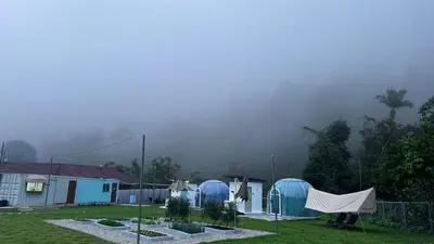 a group of blue domes in a yard with a foggy background at The Starry Dome Couple Room in Cameron Highlands