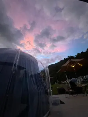 a clear tent with a sunset in the background at The Starry Dome Couple Room in Cameron Highlands