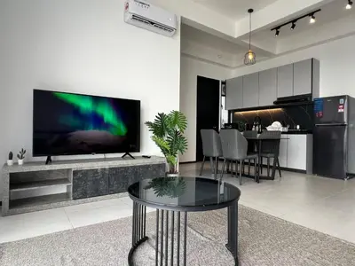 a living room with a large flat screen tv on a wall at Urban Suites TWO Or THREE Bedroom Georgetown by Annesui Cottage in Jelutong
