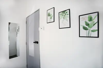 a bathroom with three pictures on the wall and a mirror at HangoutSpacez Queensbay at Bayan Lepas Penang in Bayan Lepas
