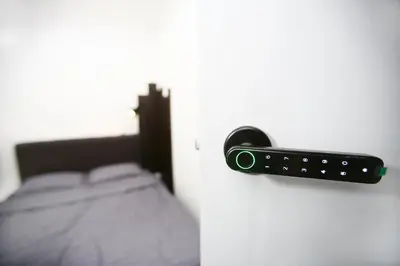 a remote control on a wall next to a bed at HangoutSpacez Queensbay at Bayan Lepas Penang in Bayan Lepas