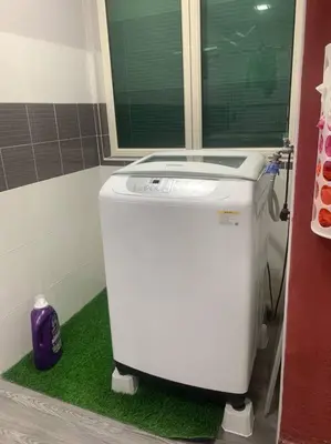 a washing machine sitting on a green rug in a bathroom at ADZ Islam Homestay Simpang Pulai in Kampong Kepayang