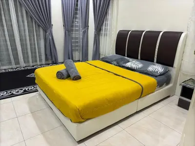 a bedroom with a bed with a yellow bedspread and a yellow blanket at ADZ Islam Homestay Simpang Pulai in Kampong Kepayang