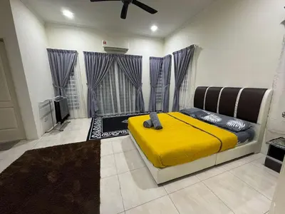 a bedroom with a bed with a yellow blanket at ADZ Islam Homestay Simpang Pulai in Kampong Kepayang