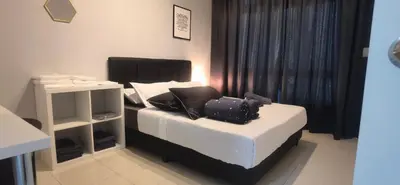 a bedroom with a bed with a laptop on it at Anderson Suite by Hopestay Property Management in Ipoh