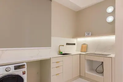 a kitchen with white cabinets and a washer and dryer at Designer Suites 2BR Apartment in Penang near George Town Self Check-In WiFi Partial Seaview in Jelutong