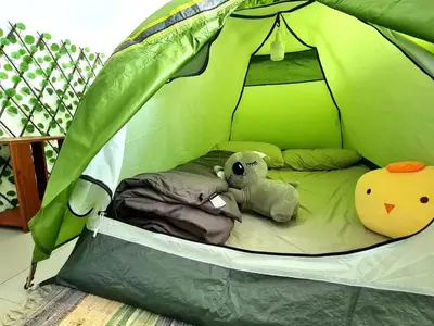 a green tent with two stuffed animals in it at SweetHome Brinchang Pent House - Pasar Malam area in Brinchang