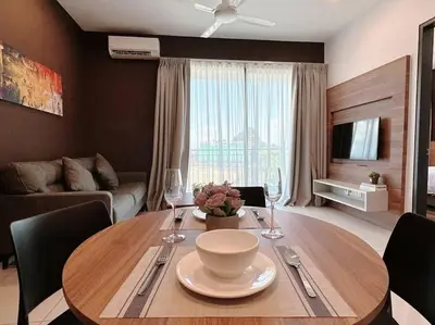 a living room with a wooden table with a bowl and wine glasses at Sunway Onsen Suite Cozy Homestay in Ipoh