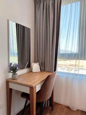 a desk with a window and a table with chairs at Sunway Onsen Suite Cozy Homestay in Ipoh