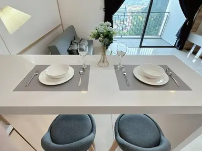 a table with plates and glasses and a vase of flowers at Sunway Onsen Suite Cozy Homestay in Ipoh