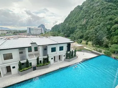 a house with a swimming pool next to a mountain at Sunway Onsen Suite Cozy Homestay in Ipoh