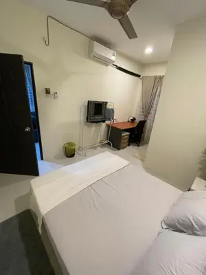 a bedroom with two white beds and a desk at Inang Homestay in Teluk Intan