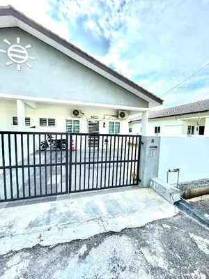 a white house with a gate and a fence at Inang Homestay in Teluk Intan