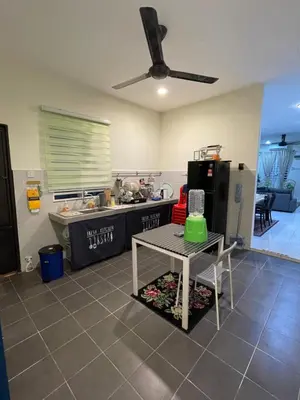 a kitchen with a table in the middle of it at Inang Homestay in Teluk Intan
