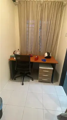an office with a desk and a chair in front of a window at Inang Homestay in Teluk Intan