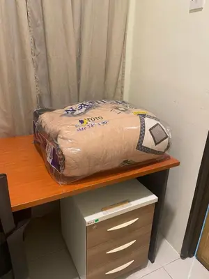 a blanket sitting on top of a table at Inang Homestay in Teluk Intan