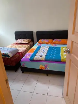 two beds sitting next to each other in a room at Highlands Double Story House in Tanah Rata