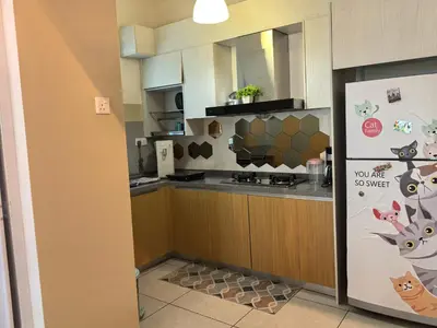 a kitchen with a counter and a refrigerator at Sweet Homestay Meritus by Moowin in Perai