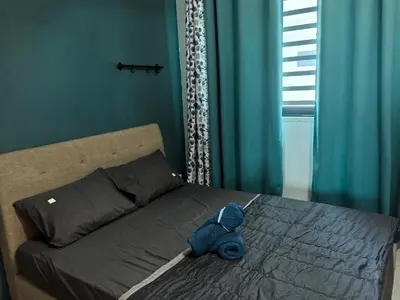 a blue teddy bear sitting on top of a bed at Sweet Homestay Meritus by Moowin in Perai