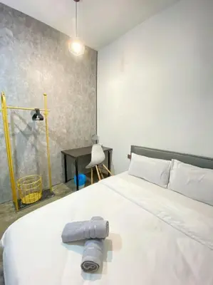 a bedroom with a large white bed and a desk at Pillow Talk 3 Hours Room in Bukit Mertajam